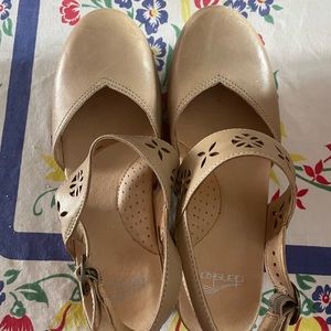 Dansko sling back clog in taupe leather with floral cutouts.